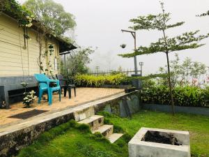 a patio with a blue chair and a table at LAZY RETREAT in Vagamon