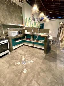 a kitchen with a counter and a table in it at Alma Livre Pipa Casa de Praia in Pipa