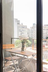 a table with a vase of flowers on a balcony at Moderno Monoambiente en Area Palermo A Estrenar Con Balcón y Vista Abierta in Buenos Aires