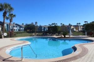 a swimming pool in a resort with palm trees and houses at Villa near Disney, Orlando in Kissimmee