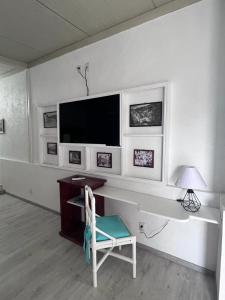 Cette chambre comprend un bureau avec une télévision et une chaise. dans l'établissement Los Abuelos Hostal Huajuapan, à Huajuapan de León
