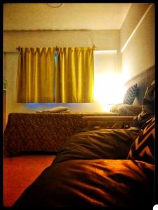 een slaapkamer met een geel gordijn en een raam bij departamentos sebas llanoo san rafael PLENO CENTRO in San Rafael