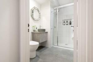 a white bathroom with a toilet and a shower at The Ranch In The Heart Of Launceston w/ Free Wifi in Launceston