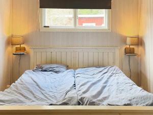 Bottnaryd的住宿－Holiday home Bottnaryd II，卧室内的一张未铺好的床,配有两盏灯