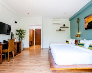 um quarto com uma grande cama branca e uma secretária em RiverTree Villa & Resort em Kampot