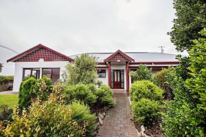 a red and white house with a brick walkway at Sea Breeze - Spacious home with lovely ocean views in Port Elliot