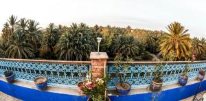 a blue fence with potted plants on a balcony at Dar marco polo in Erfoud