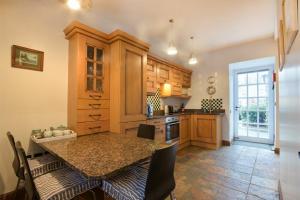 a kitchen with a table with chairs and a counter top at No9 Budle Sands in Bamburgh