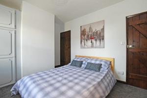 a bedroom with a bed with a checkered blanket at Beach Retreat in Seahouses