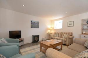 a living room with two couches and a tv at Croft Cottage Alnwick in Alnwick