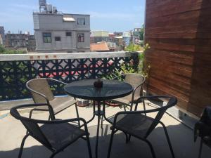 a table and chairs on a balcony with a view at Play Kimnen B&B in Jincheng