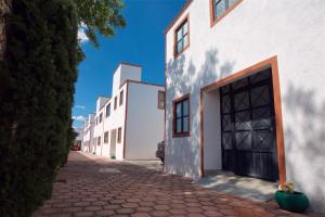 un bâtiment blanc avec une grande porte dans une rue dans l'établissement Casa Amaiur, à Huichapan