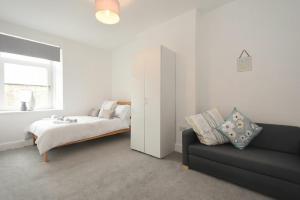 a bedroom with a bed and a couch and a window at Castaway in Amble