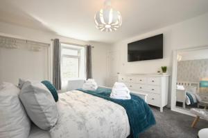 1 dormitorio con 1 cama y TV en la pared en Rivershield, en Warkworth