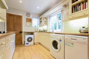 a large kitchen with a washer and dryer in it at Castle View Warkworth in Warkworth