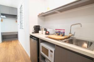 a kitchen with a sink and a counter top at The Bungalows in Mission Beach