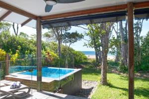 een zwembad met uitzicht op het strand vanuit een huis bij The Bungalows in Mission Beach