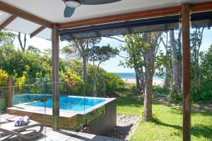 a swimming pool with a view of the beach from a house at The Bungalows in Mission Beach