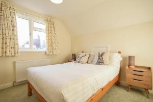 a bedroom with a large white bed and a window at Annstead House in Seahouses