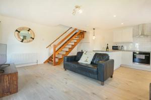 a living room with a couch and a staircase at Coastal Plaice in Beadnell