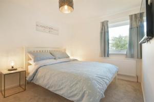 a bedroom with a bed and a window at Coastal Plaice in Beadnell
