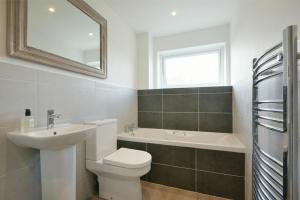 a bathroom with a sink and a toilet and a bath tub at Coastal Plaice in Beadnell +9 photos