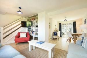 a living room with a red chair and a table at Dunford Cottage in Bamburgh