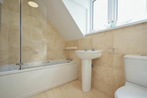 a bathroom with a sink and a toilet and a bath tub at Dunford Cottage in Bamburgh +16 photos