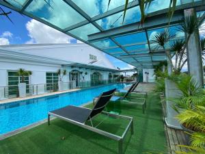 a swimming pool with lounge chairs in a building at Wesberly Apartments in Kuching