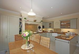 a kitchen with a table with a vase of flowers on it at Grange Cottage in Alnmouth