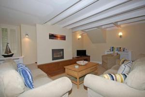 a living room with two couches and a table at Grange Cottage in Alnmouth