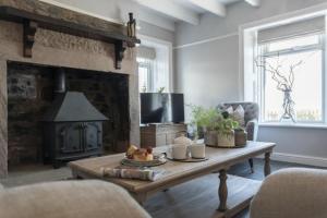 a living room with a table and a fireplace at Creel Cottage, Craster in Craster