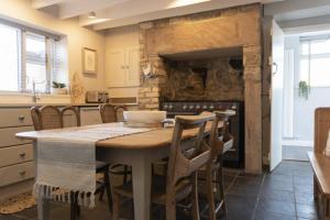 a kitchen with a table with chairs and an oven at Creel Cottage, Craster in Craster