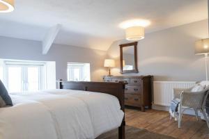 a bedroom with a bed and a dresser and a mirror at Creel Cottage, Craster in Craster