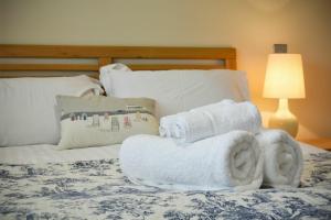 a bed with white towels on top of it at Martins Cottage in Alnmouth