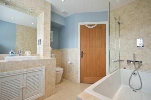 a bathroom with a tub and a sink and a toilet at Martins Cottage in Alnmouth