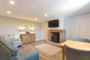 a living room with a couch and a fireplace at Dairymaid's Cottage in Amble