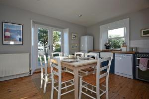 a kitchen with a table and chairs in a kitchen at Pebble Cottage in Long Houghton