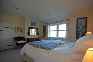 Un dormitorio con una cama grande y una ventana en Pebble Cottage, en Long Houghton