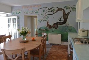 沃克的住宿－Honeysuckle Cottage Wark on Tyne，厨房配有一张桌子,墙上挂着一幅木壁画
