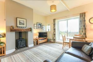 a living room with a couch and a fireplace at Bellshill Cottage in Belford