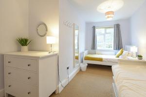 a bedroom with a bed and a dresser and a window at Bellshill Cottage in Belford
