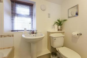 a white bathroom with a toilet and a sink at Bellshill Cottage in Belford +10 photos