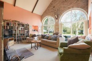 Una sala de estar con un sofá y una ventana grande. en Craster Tower Coach House, en Craster