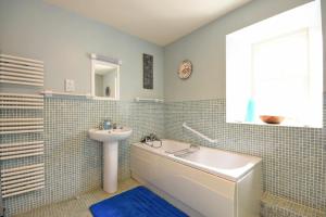 Un baño con lavabo y bañera y un lavabo. en Craster Tower Coach House, en Craster 32 fotos más