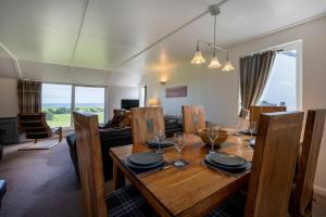 a dining room with a wooden table in a living room at Fidra in Embleton