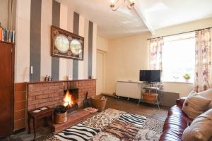 a living room with a fireplace and a couch at Kittiwake Cottage, Budle Bay in Bamburgh