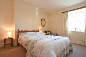 um quarto com uma cama grande e uma janela em Kittiwake Cottage, Budle Bay em Bamburgh