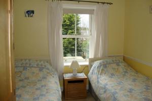 a bedroom with two beds and a window at Briar Cottage in Wark