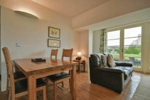 uma sala de estar com uma mesa de madeira e um sofá em Northrawe em Bamburgh